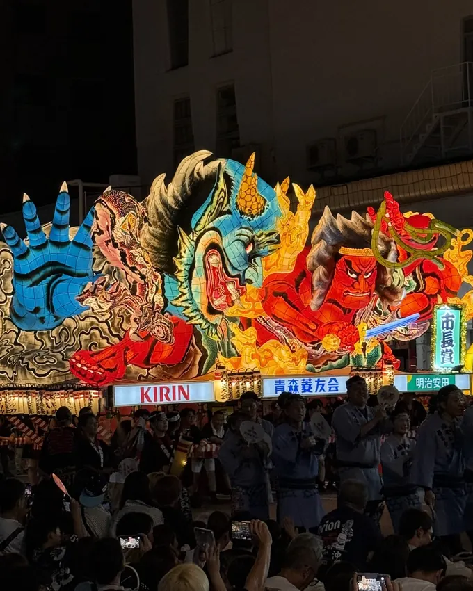 Illuminated Nebuta float of a flame-wreathed warrior at night, Aomori